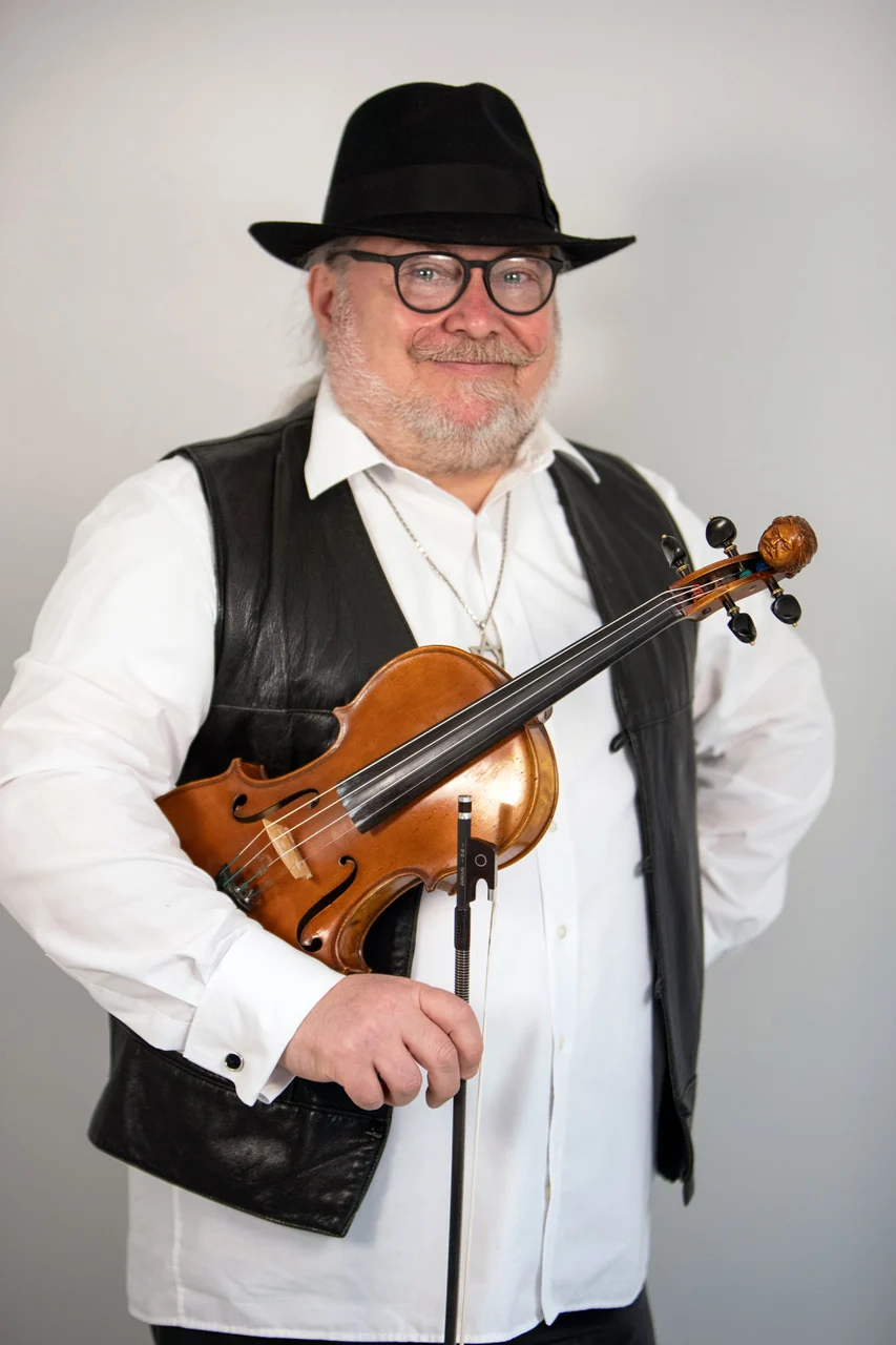 Igor Epstein with his violin, wearing a black hat and waistcoat
