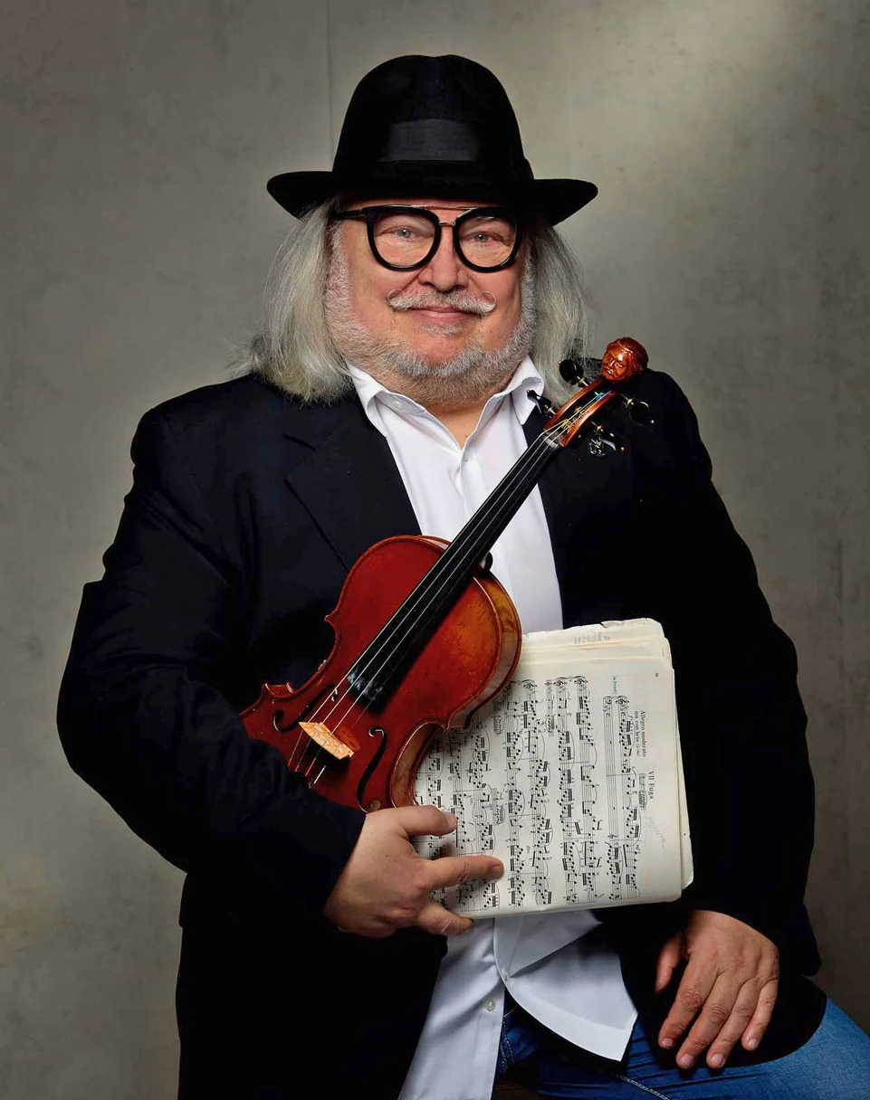 Igor Epstein holding a violin and sheet music